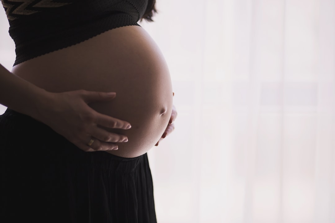 Rückenschmerzen in der Schwangerschaft: schwangere Frau stützt ihren unteren Rücken